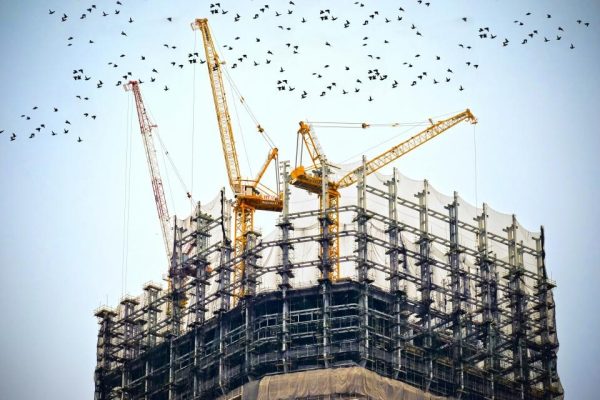 Construction cranes above a building under construction