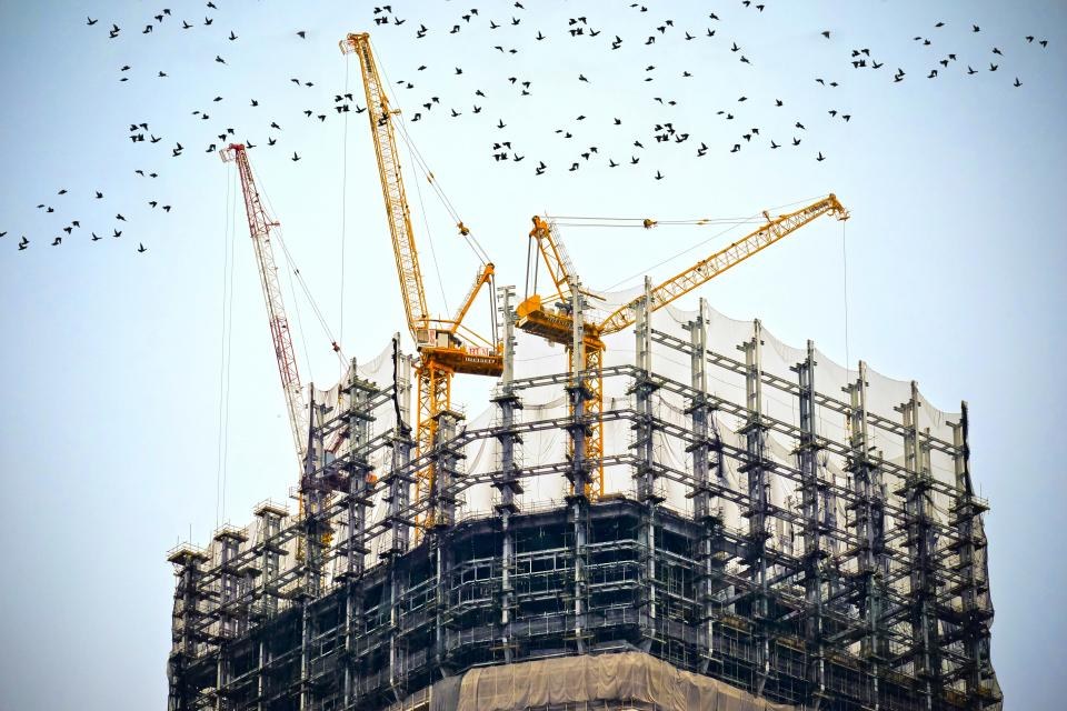 Construction cranes above a building under construction