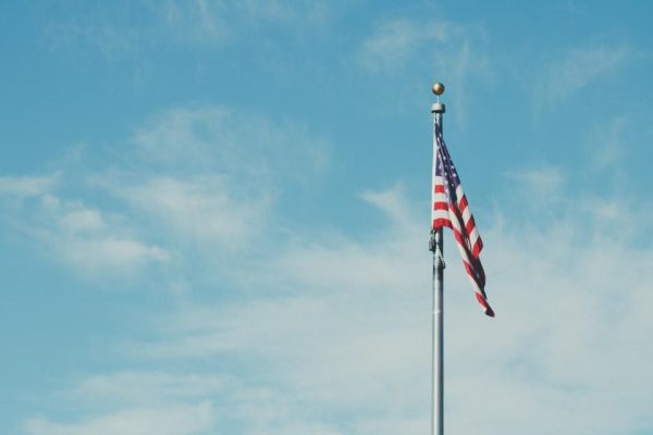 National flag flying on a pole under a blue sky with clouds