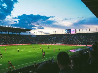 Football match under floodlights in a stadium at dusk