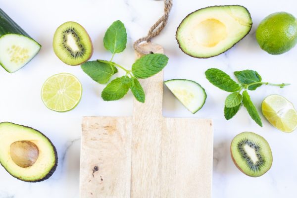 Avocado, kiwi, lime and mint on a white board
