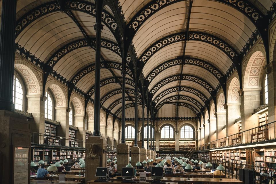 Vaulted hall with long tables and arched windows