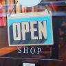 Open shop sign hanging in a shop window
