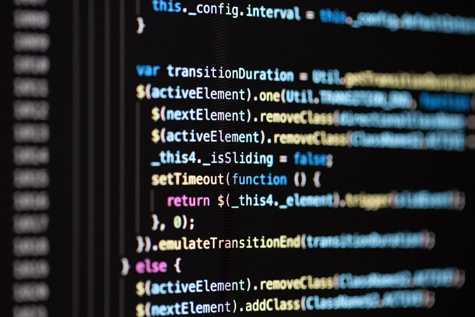 Close-up of JavaScript source code on a dark screen