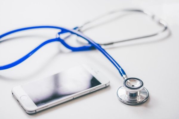Blue stethoscope resting beside a smartphone