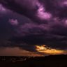 Dark purple storm clouds with lightning at sunset