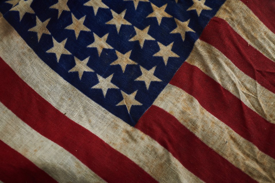 Close-up of a weathered flag with stars and stripes