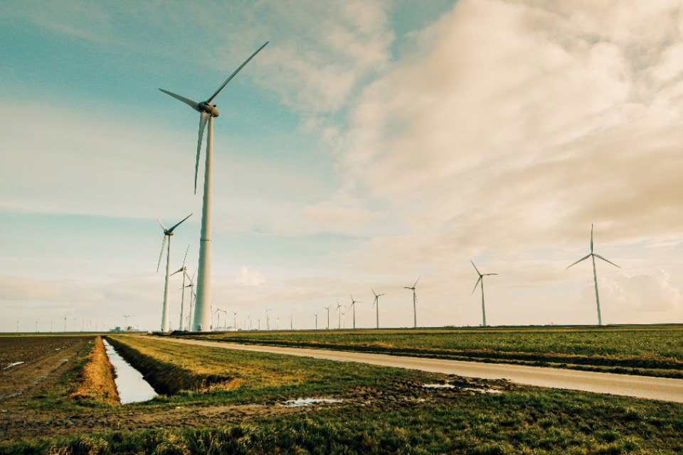 Row of wind turbines across flat farmland